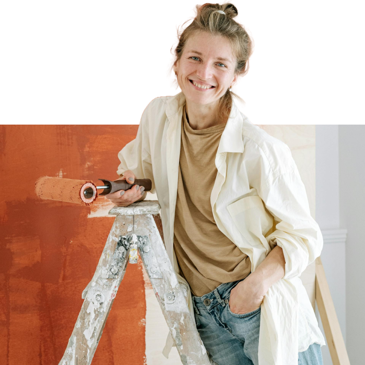 Mulher feliz pintando parede com tinta laranja